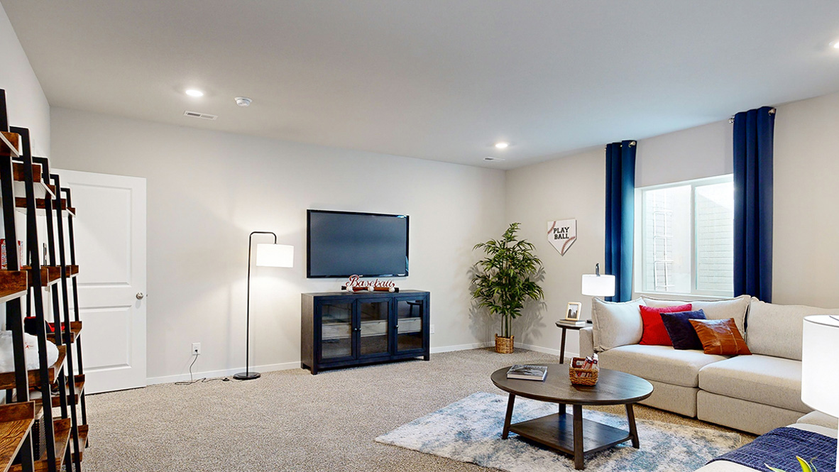 Multi-use basement room with neutral tones and doorways leading to bathroom and closet