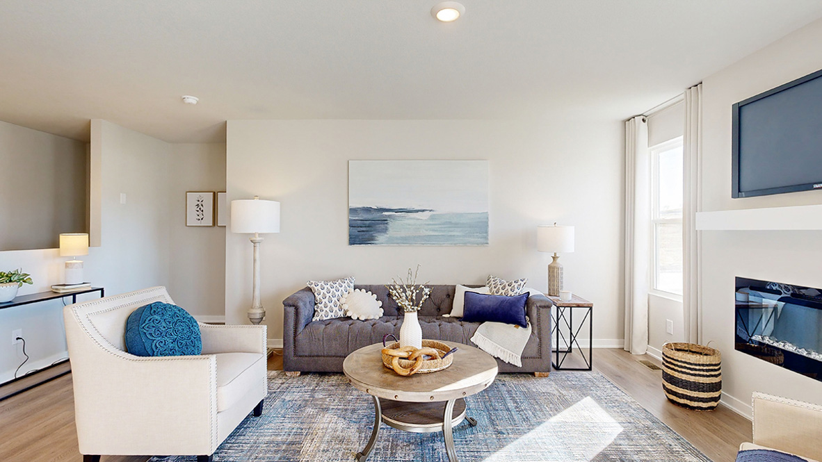 Living room with modern fixtures, electric fireplace,  and convenient central traffic flow throughout Parkview Traditions