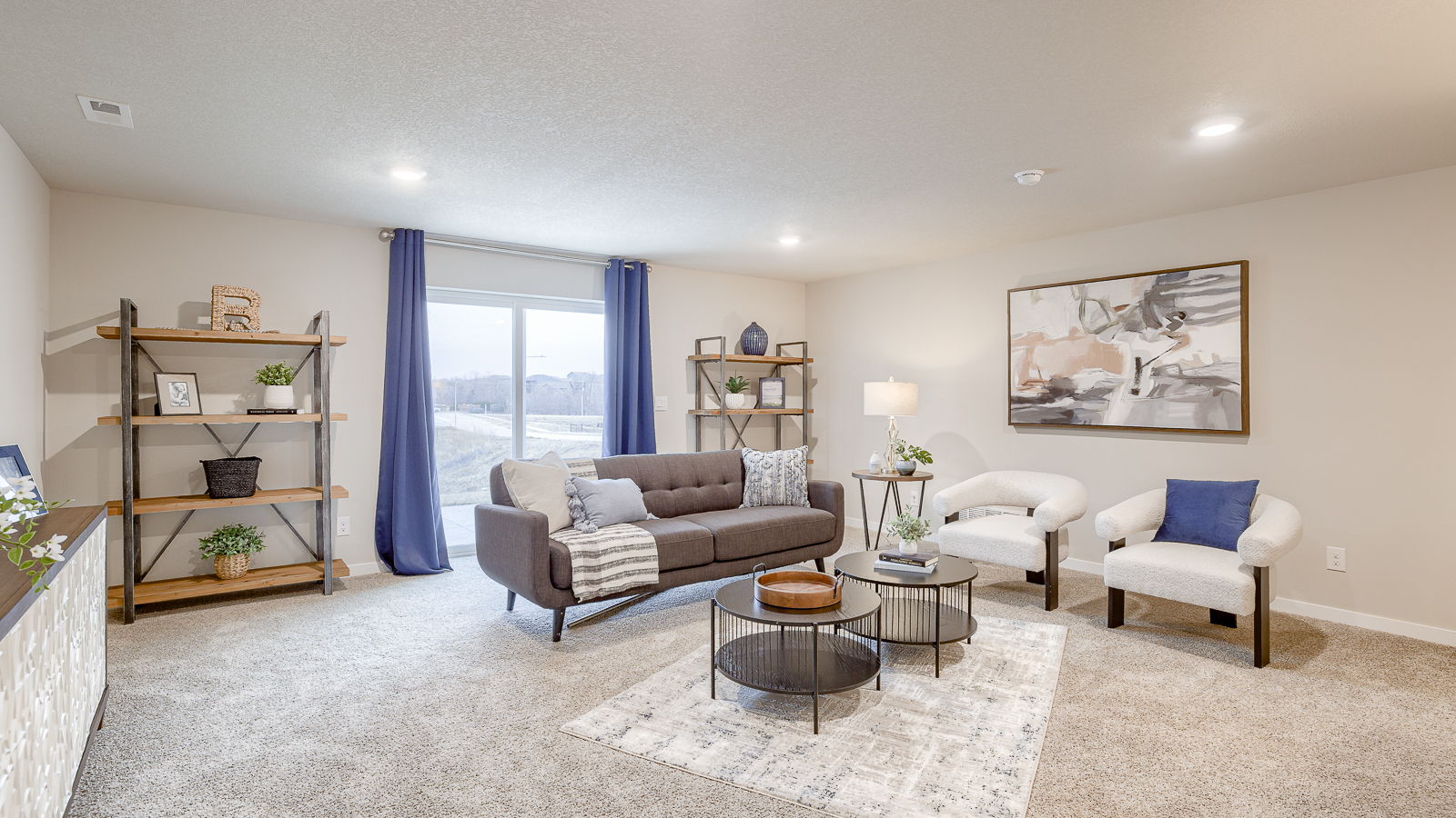 Overview of the finished basement living room in the Hamilton with sliding glass doors