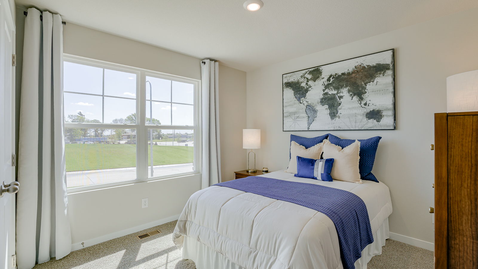 Second bedroom in the Hamilton with large  window and queen size bed