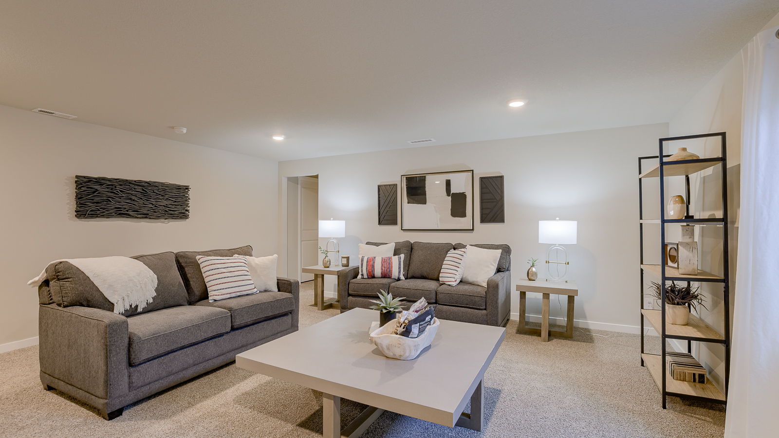Overview of the finished basement living room in the Hamilton with 2 couches and a coffee table