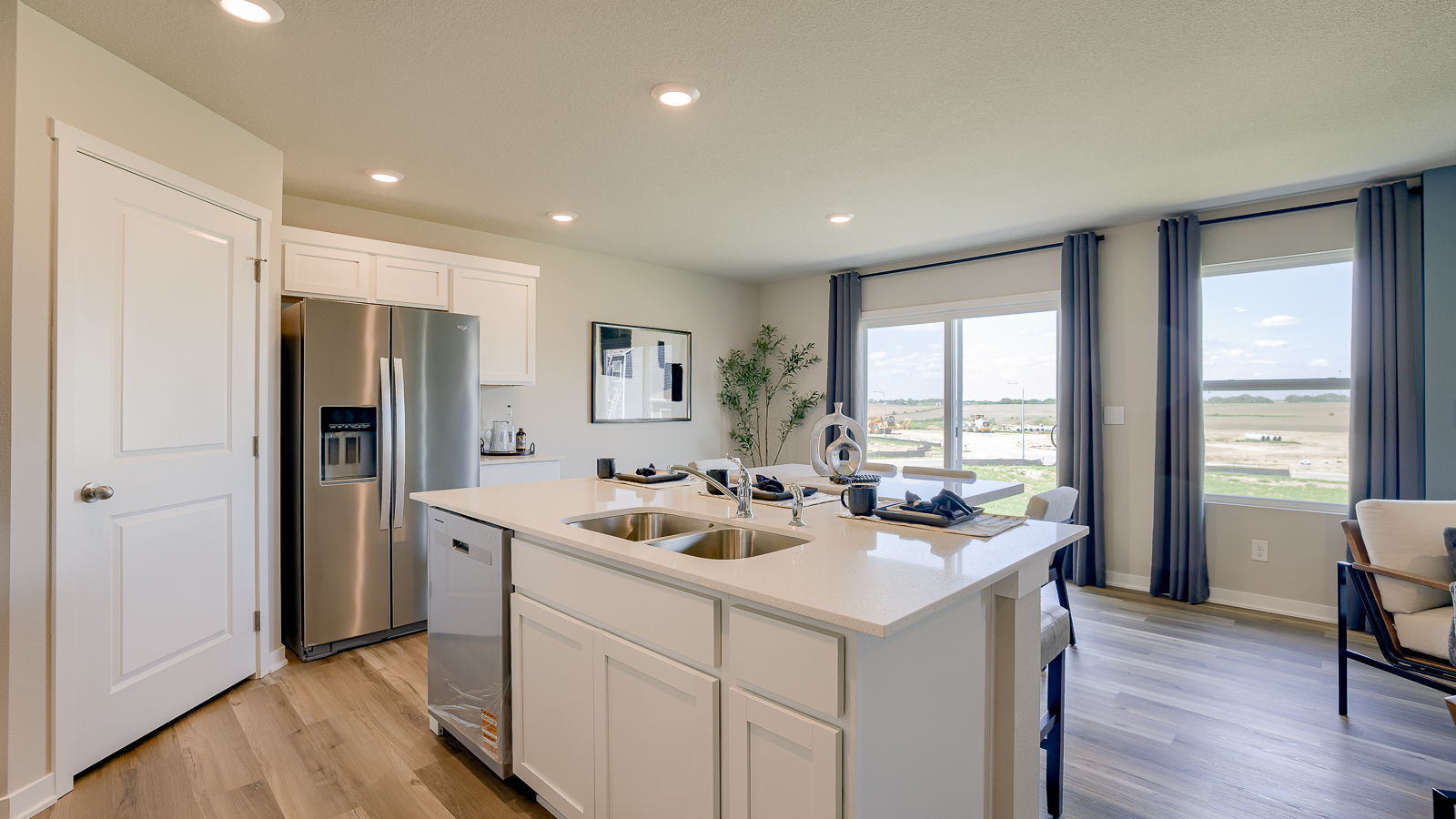 Hamilton kitchen island with sink and dishwasher facing the walkout sliding glass door