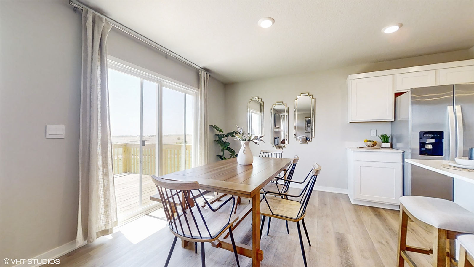 Dining room of the Hamilton with a long table seating 6 and siding glass doors