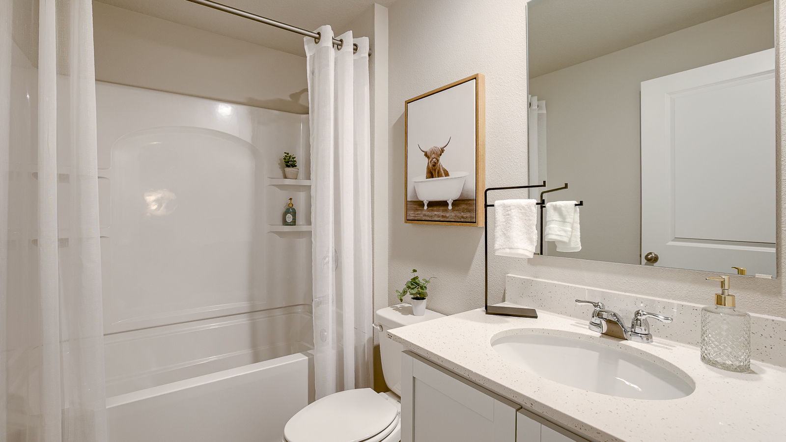 Sleek family-guest bath with single sink, mirror, cabinets, and shower-tub combination at The Hill