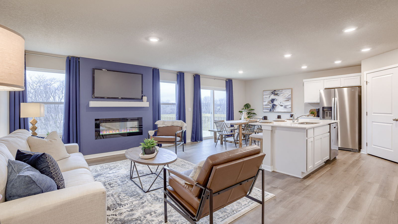 Spacious living room with view into backyard, connecting dining and kitchen areas at The Hill