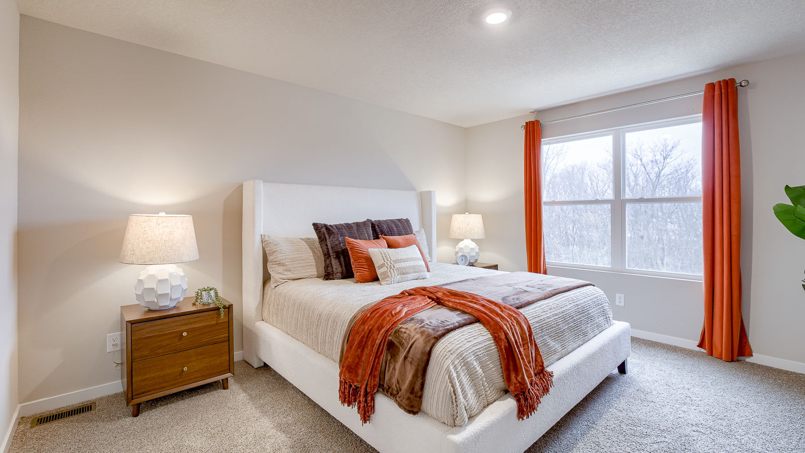 Primary bedroom features ample space, double windows, soft carpet, a stylish walk-in closet, and a private ensuite bath