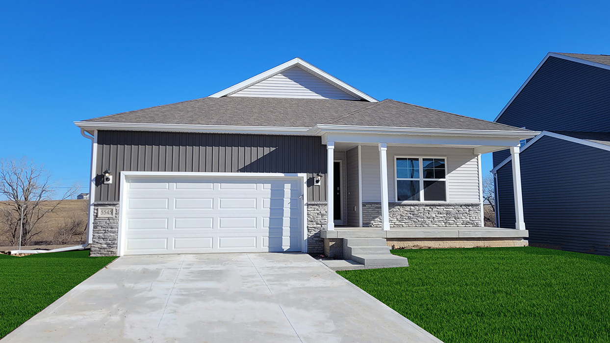 Exterior of the Hamilton with grey and white siding, stone and a covered front porch