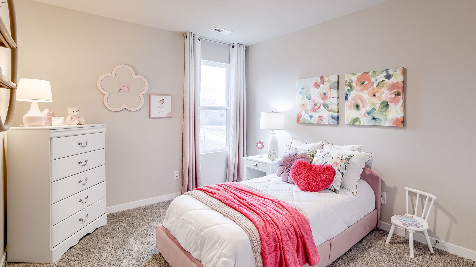 Third bedroom in the Bellhaven staged with pink and floral accents with a twin bed