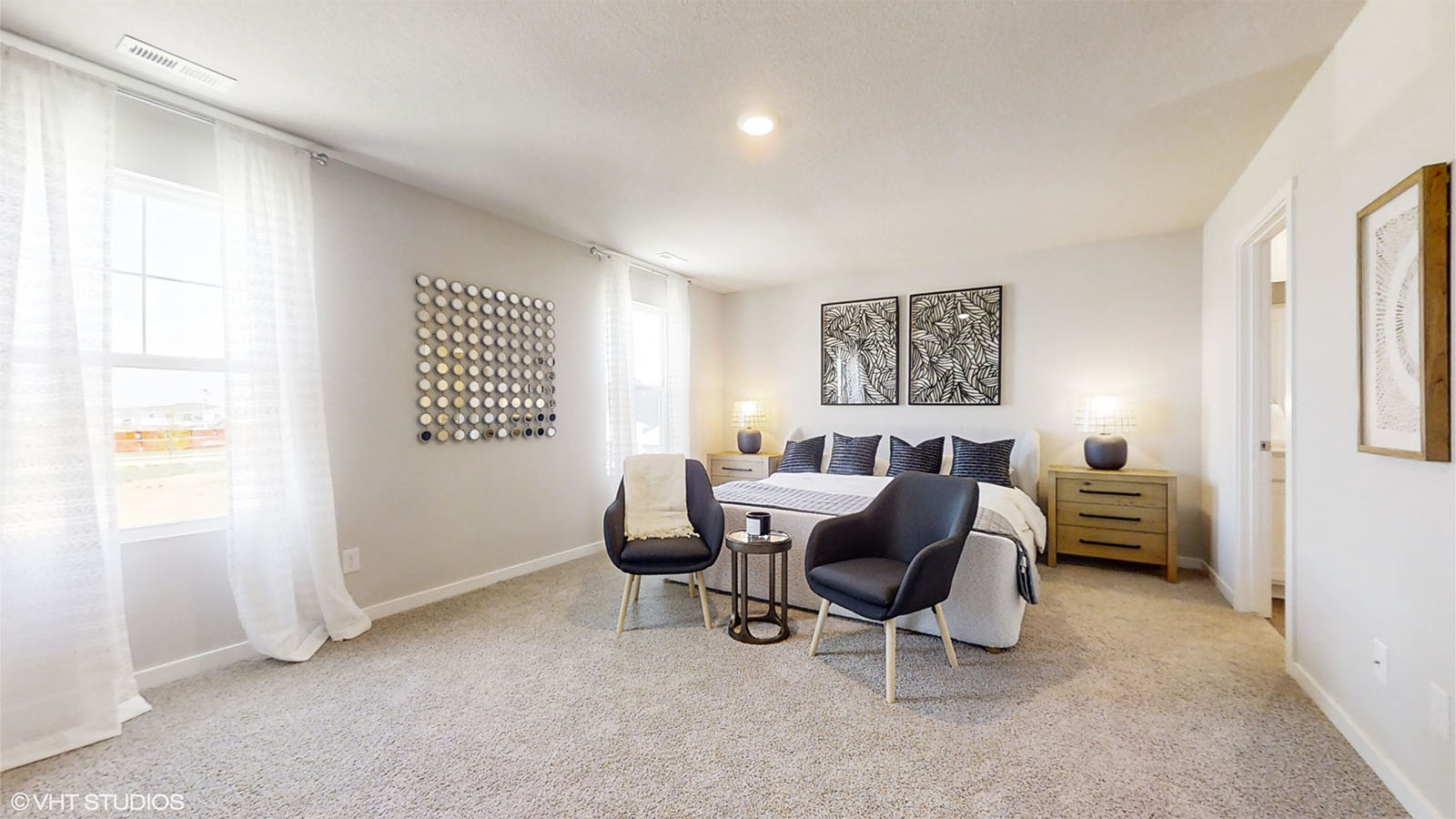 Large primary bedroom in the Bellhaven with a king bed sitting area and 2 large windows