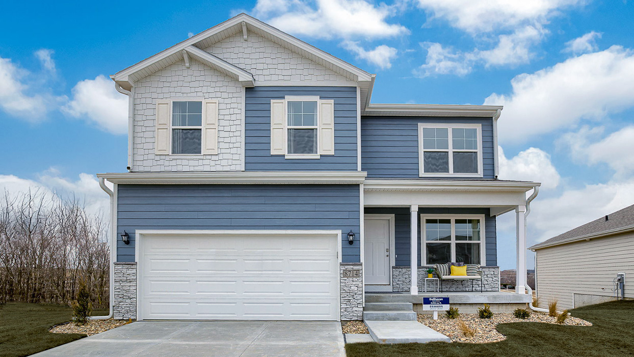 Exterior of the Bellhaven with blue siding, stone and covered front porch