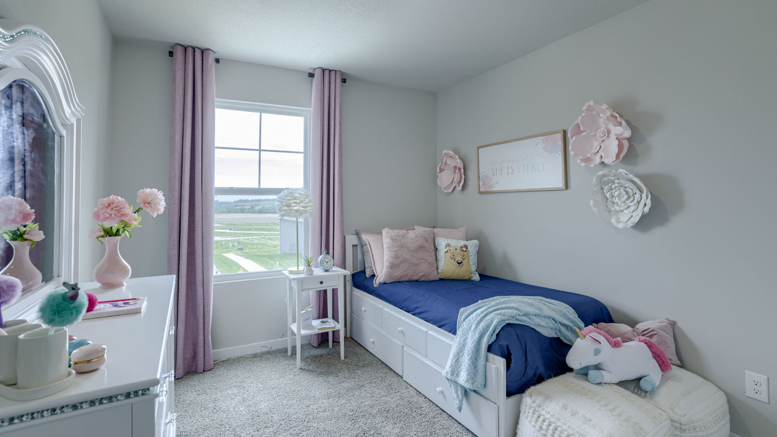 Third bedroom in the Fremont staged in pink and blue accents with a twin bed