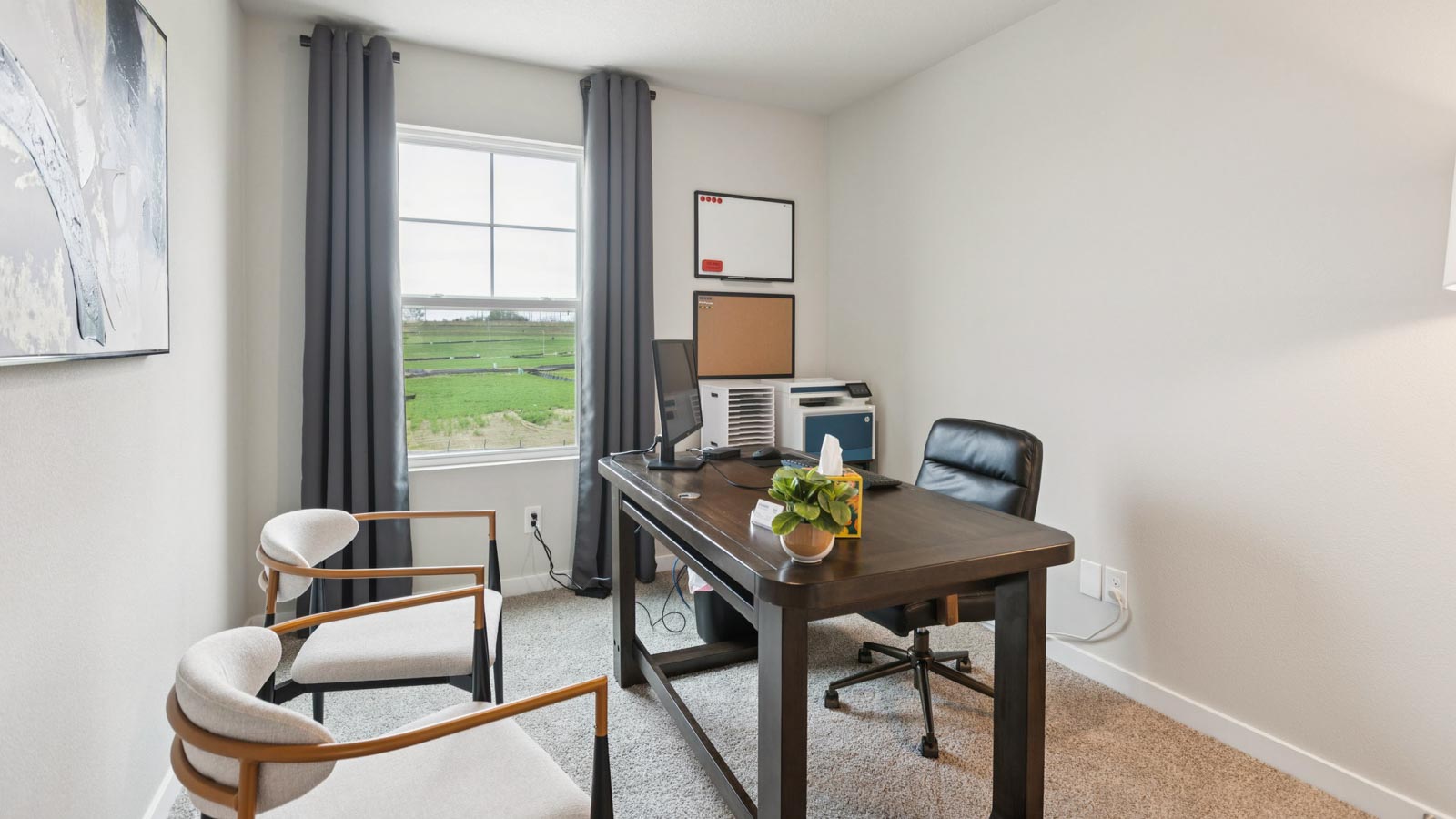 Third bedroom in the Fremont staged as a home office with a desk and chairs