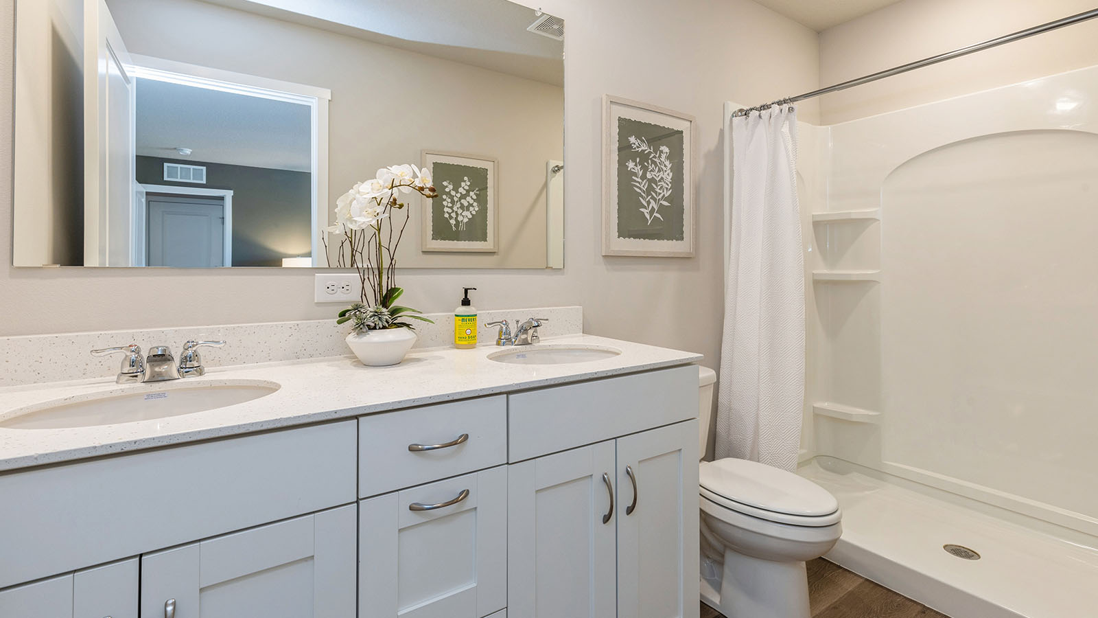 Primary ensuite bathroom with double vanity sink and walk in shower