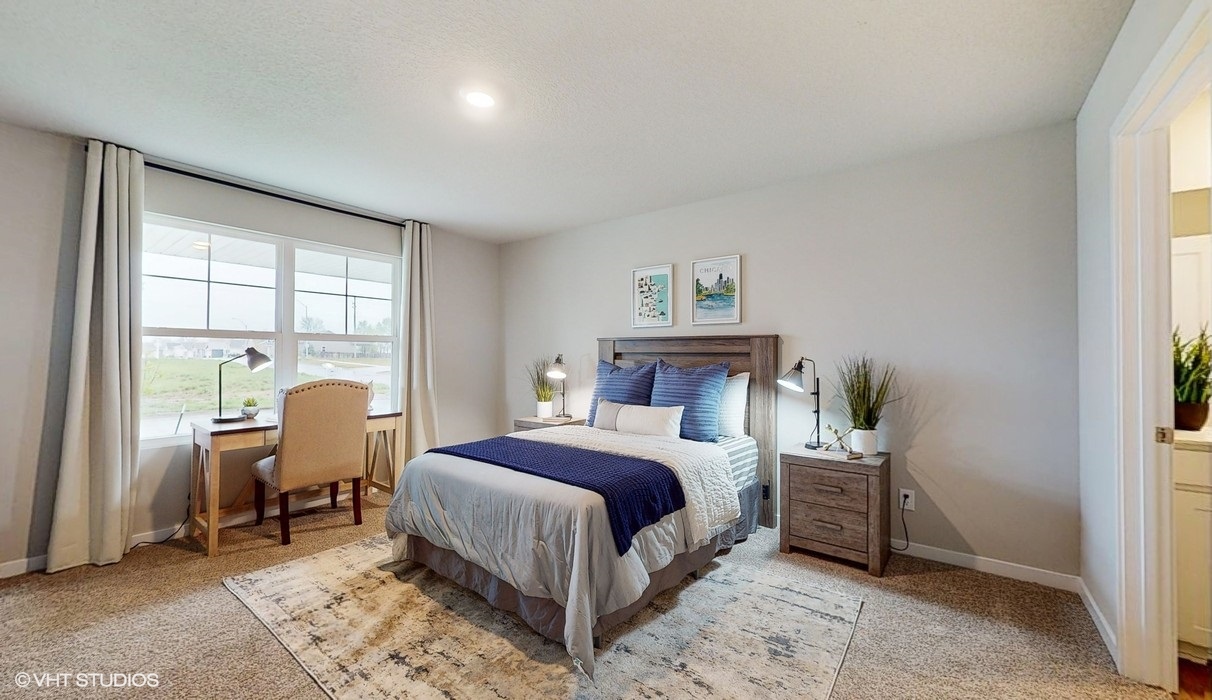 First bedroom with colorful bed and desk with chair