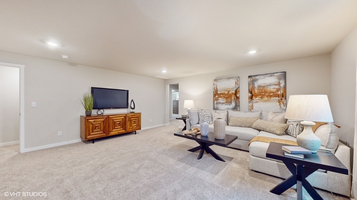 Finished basement with large sectional with tv mounted on wall