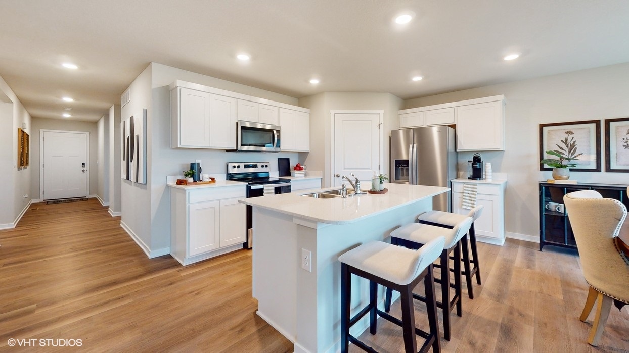 -Modern kitchen with white island and tan barstools