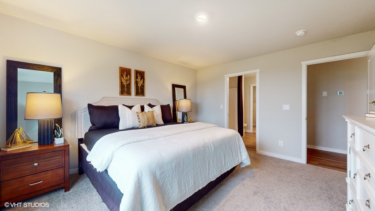 Primary bedroom with two full length mirrors next to bed