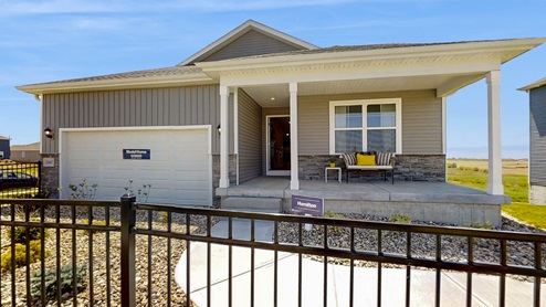 exterior photo of the Hamilton with stone, a covered front porch and 2 car garage