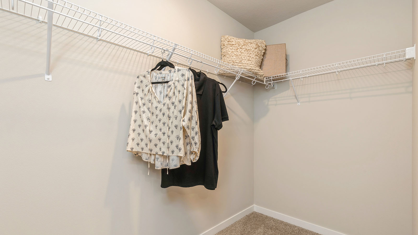 Large walk-in closet off primary bathroom with shelving and clothes