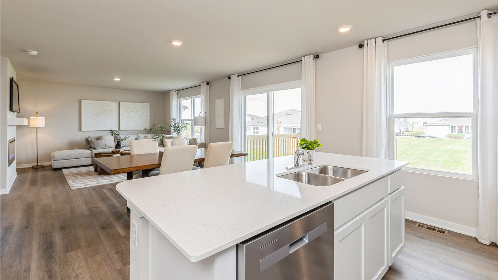 Quartz kitchen island with dishwasher overlooking dining area and living room