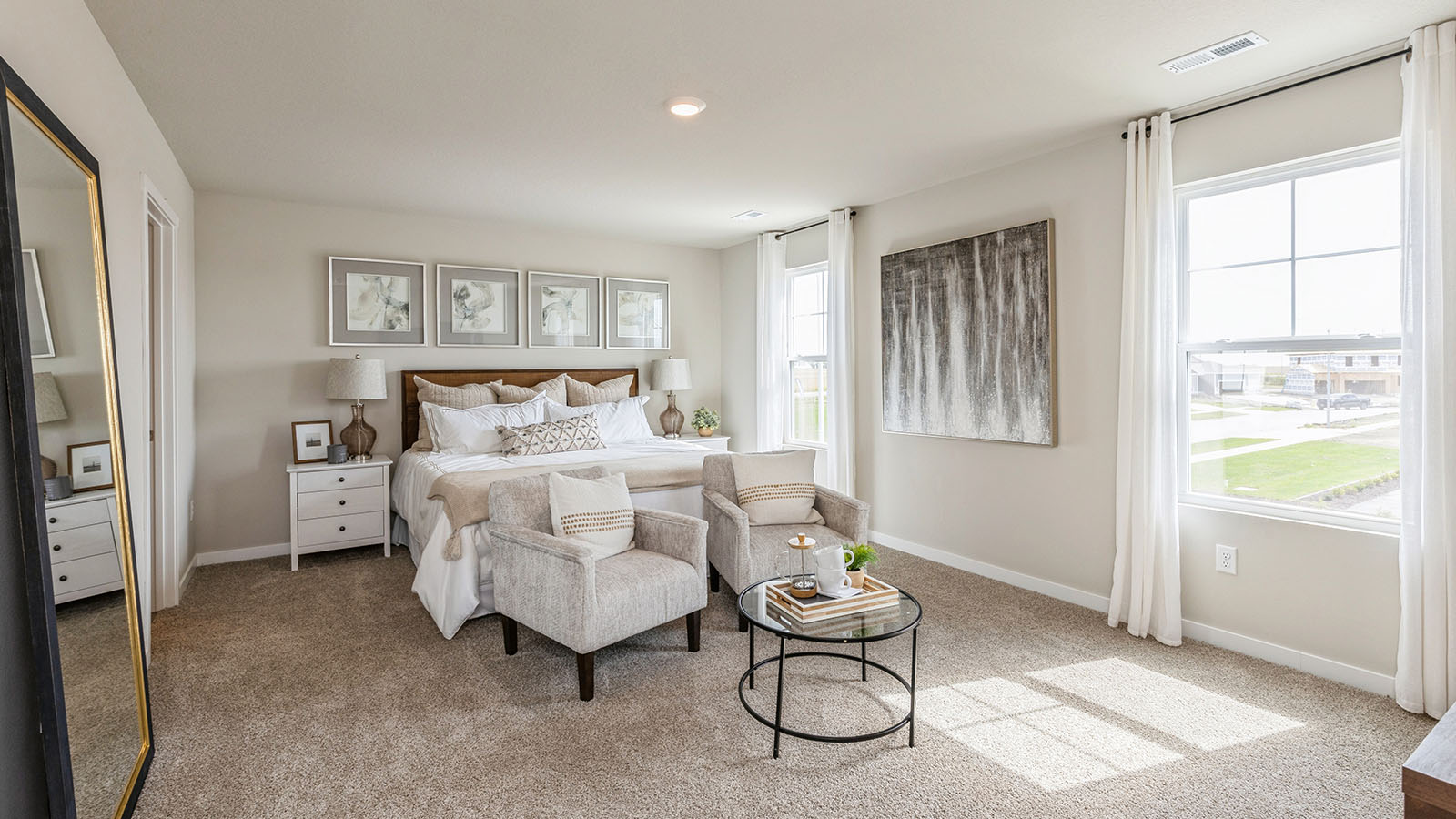 Primary bedroom with two large windows and seating area