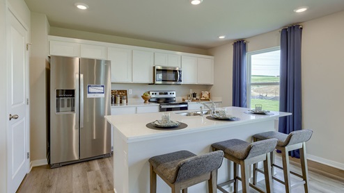White kitchen with island and 3 chairs in the Bellhaven