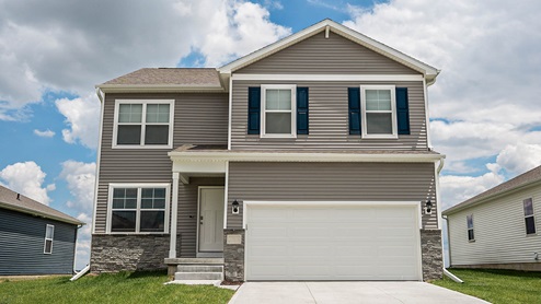 Exterior of the Bellhaven with tan siding, stone and 2 car garage