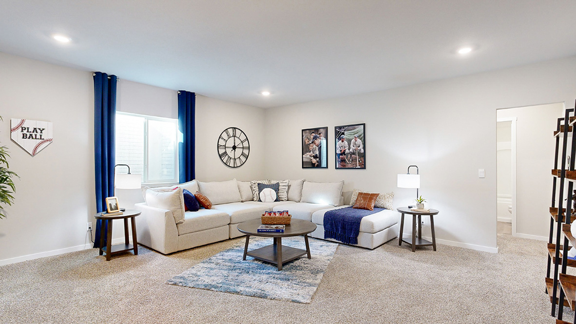 Finished basement living room in the Hamilton with large sectional couch and coffee table