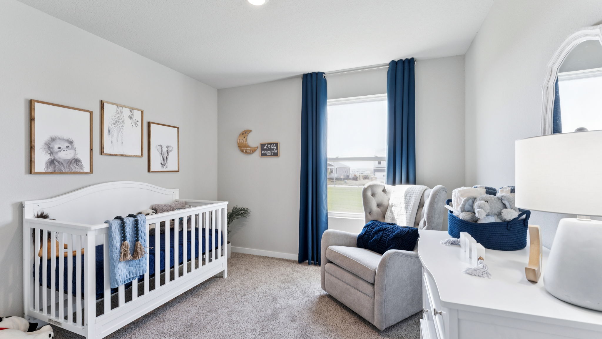 Third bedroom in the Hamilton staged as a nursery with a crib and rocking chair