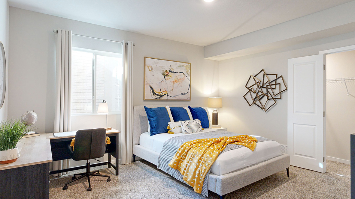 Fourth bedroom in the finished basement of the Hamilton with a queen bed and large desk