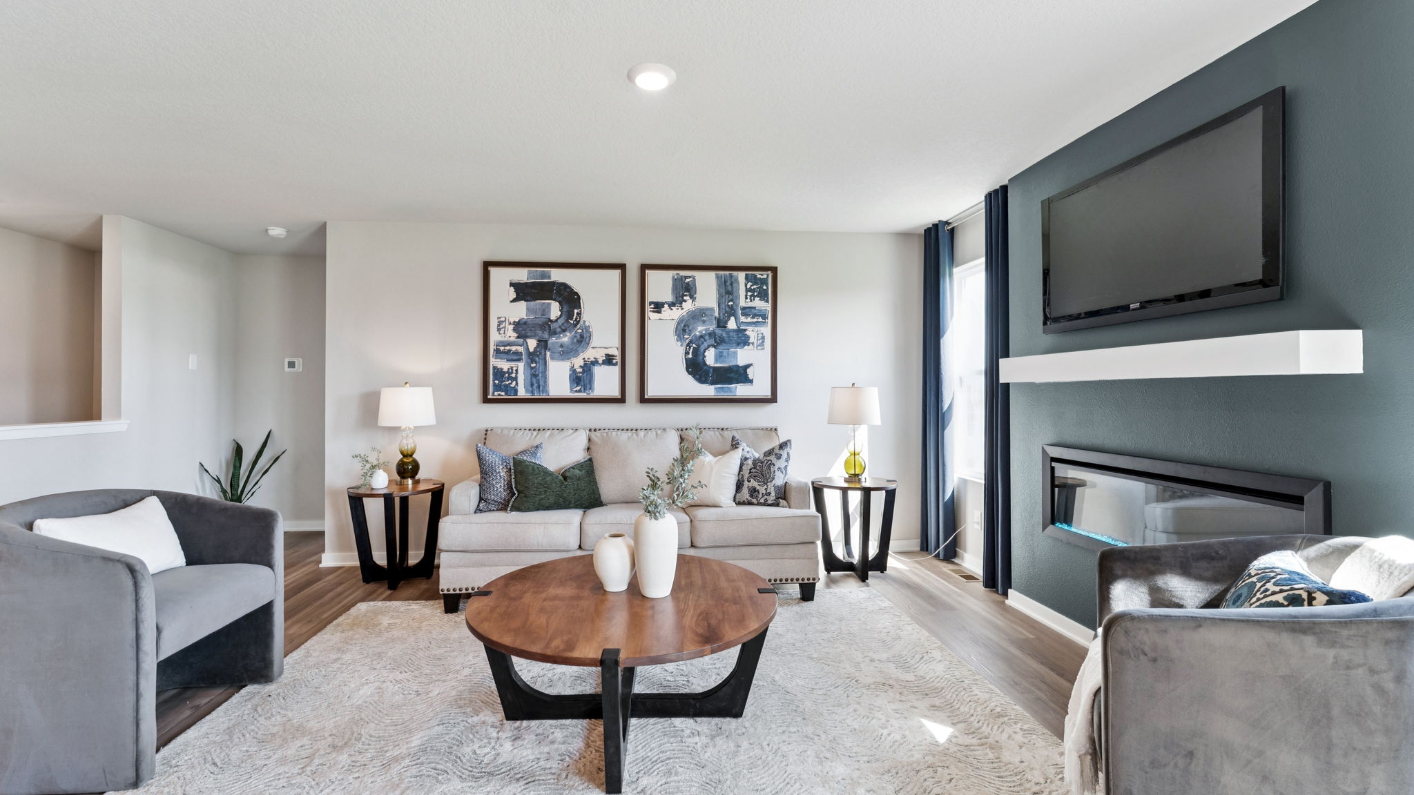 Bright living room in the Hamilton with a couch and two chairs around a coffee table