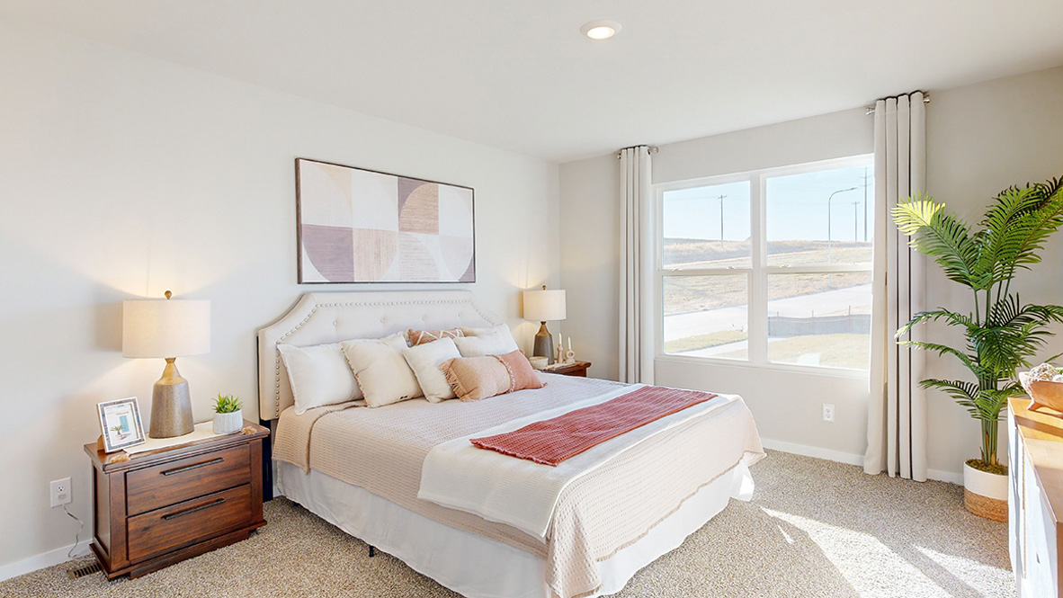 Primary bedroom in the Hamilton with a king bed and two brown night stands