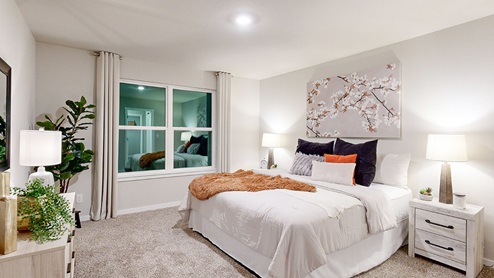 Primary bedroom in the Hamilton with a king bed and white dresser