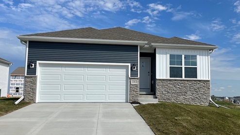 Exterior of the Roland with blue and white siding, stone and 2 car garage