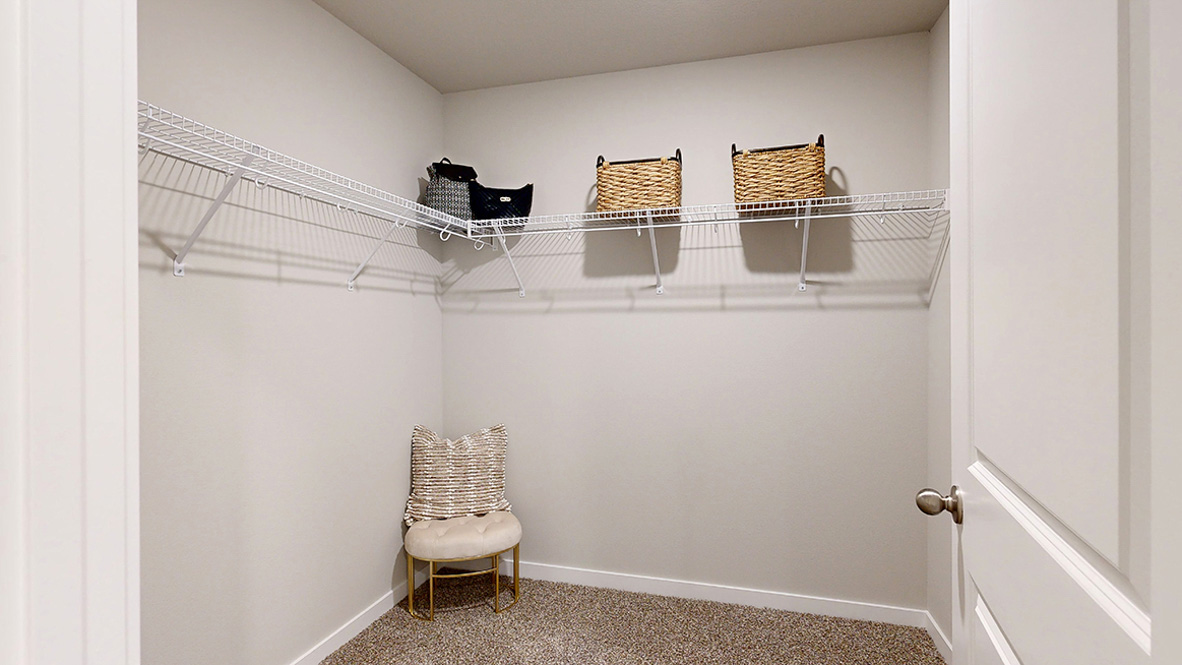 Hamilton primary walk-in closet with a chair