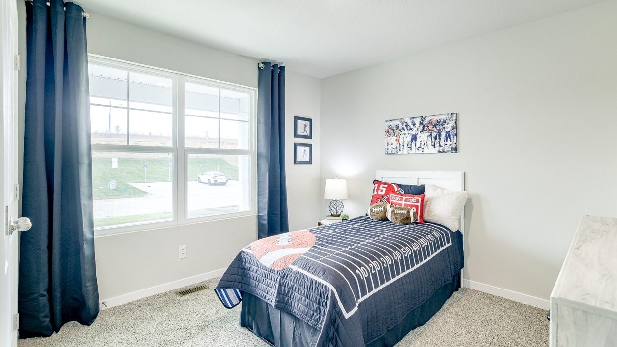 Second bedroom in the Hamilton with twin bed and large windows