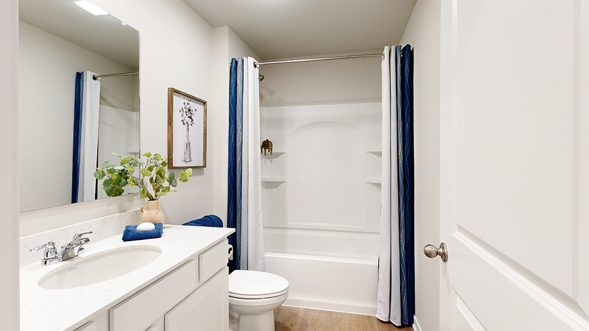 Second bathroom in the Hamilton with a queen bed and lamp