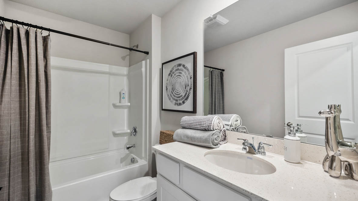 Second bathroom with white cabinets and bathtub