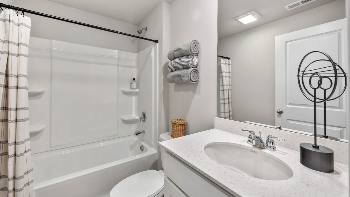 Second bathroom with white cabinets