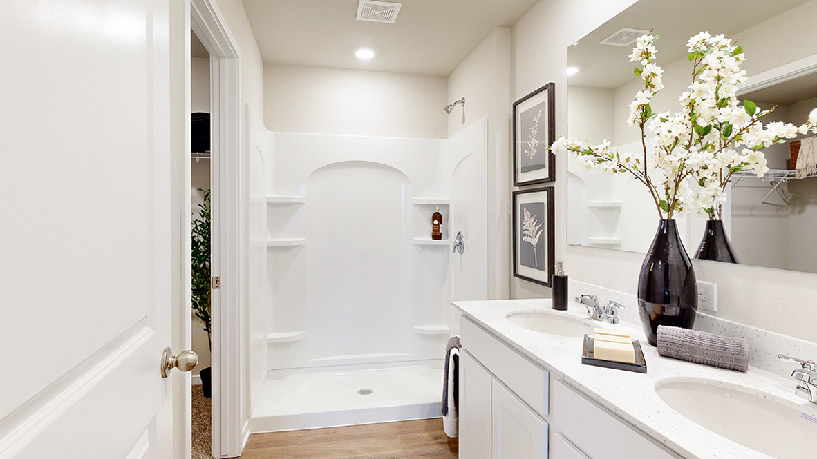 Primary bathroom in the Roland with white cabniets and walk in shower