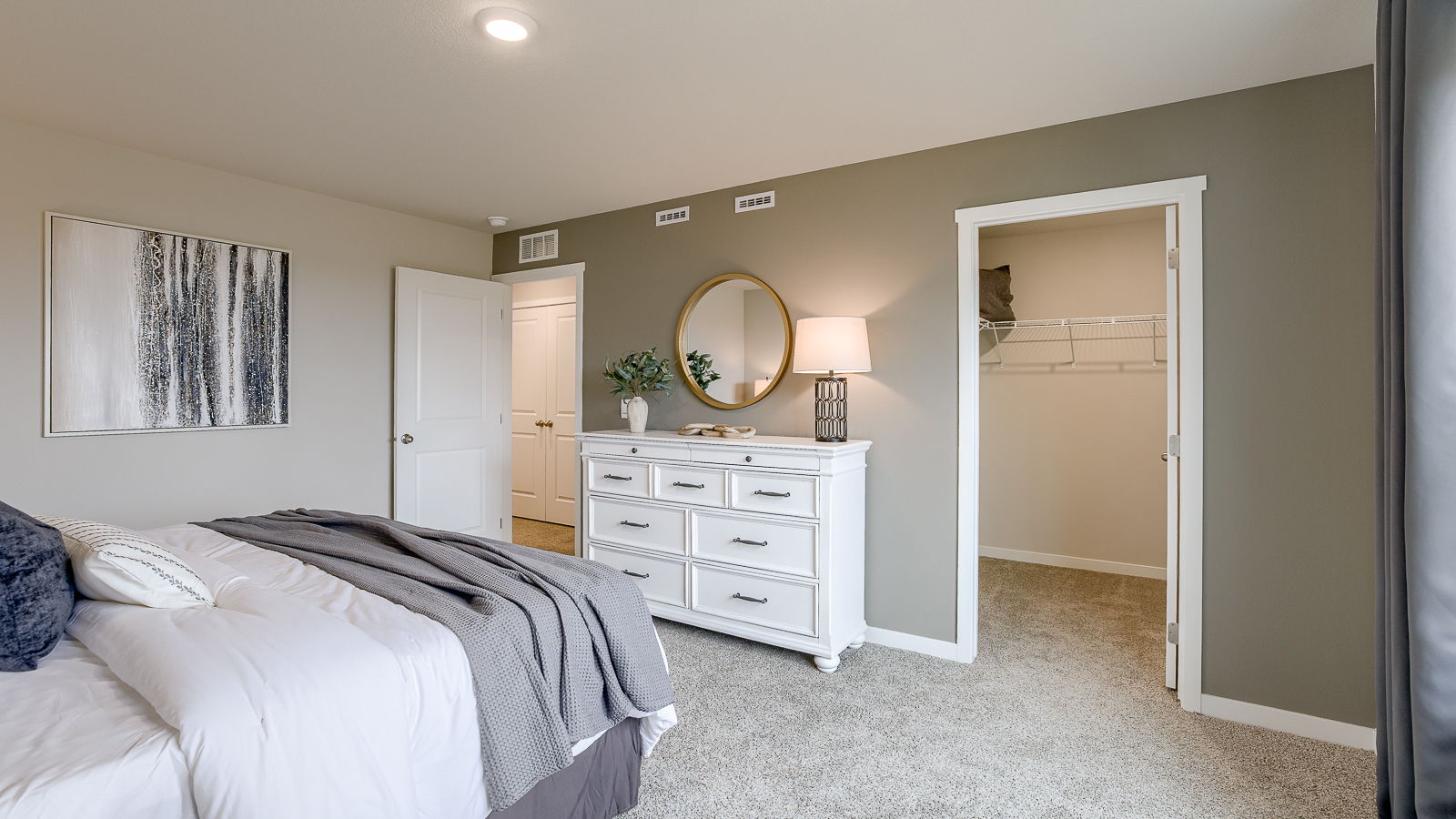 Primary bedroom in the Sydney with grey accent wall and walk-in closet