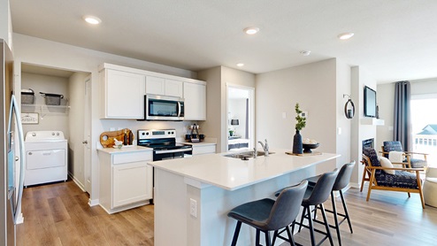 Kitchen showing laundry room and living room