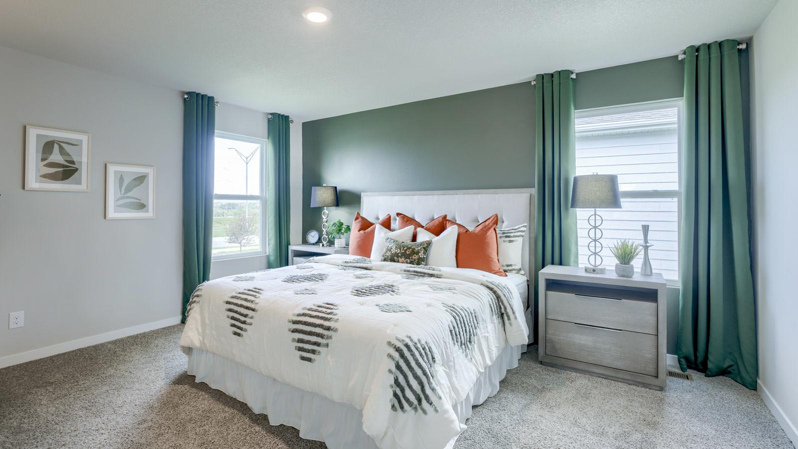 Masterbedroom of Nueville with green accent wall and king size bed.