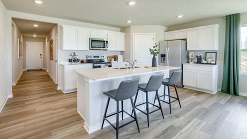 Kitchen in Neuville with large island and white cabinetry.
