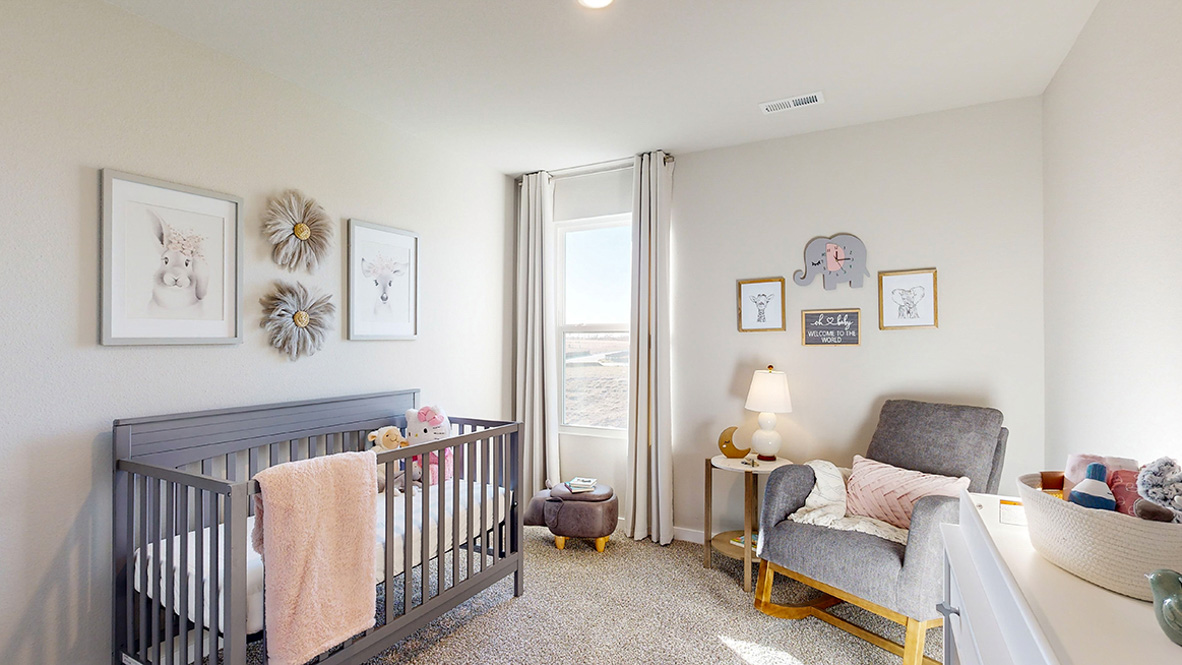 Forth bedroom staged as a nursery with crib and chair