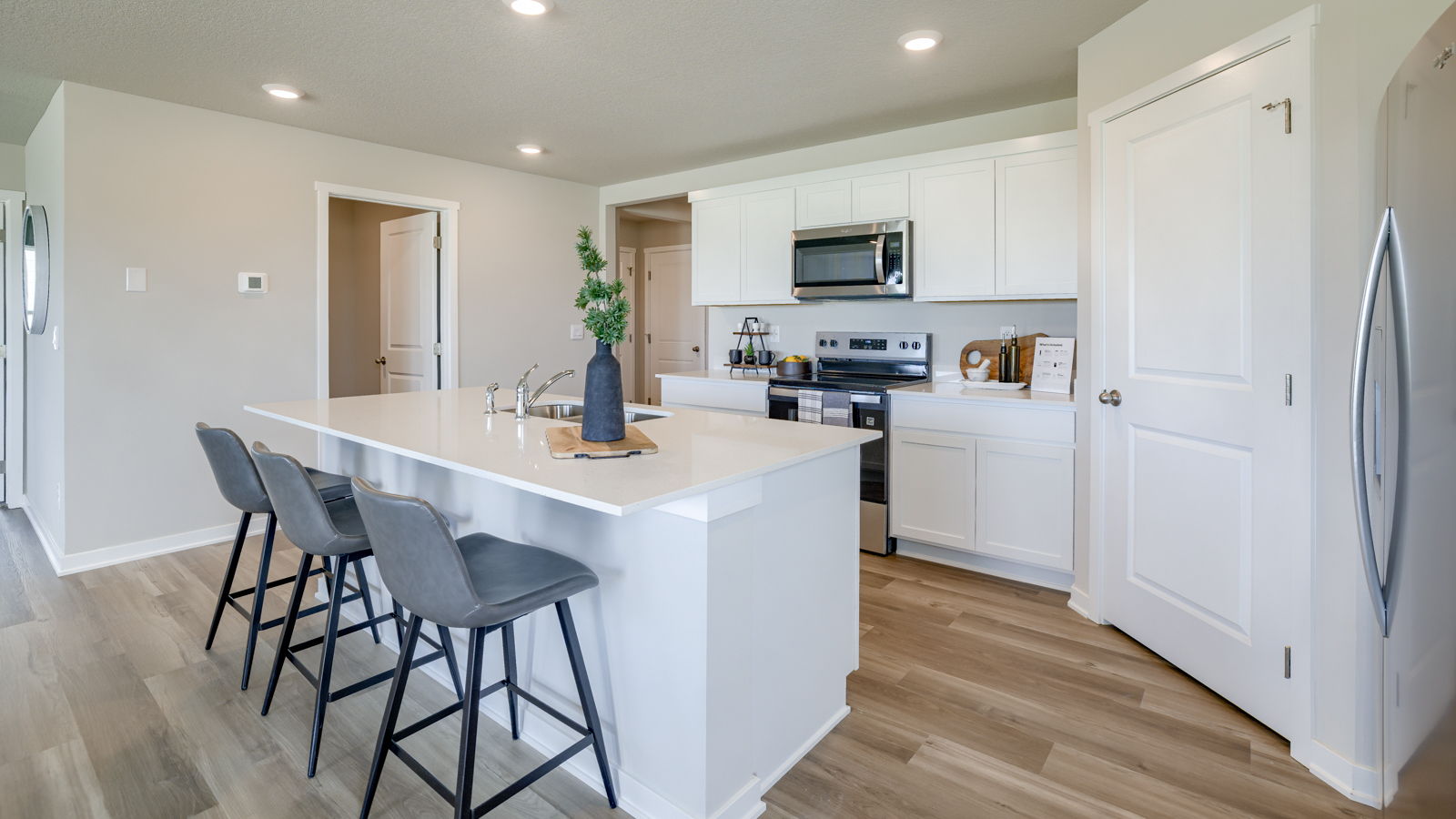 Neuville kitchen with three barstools and walk in pantry