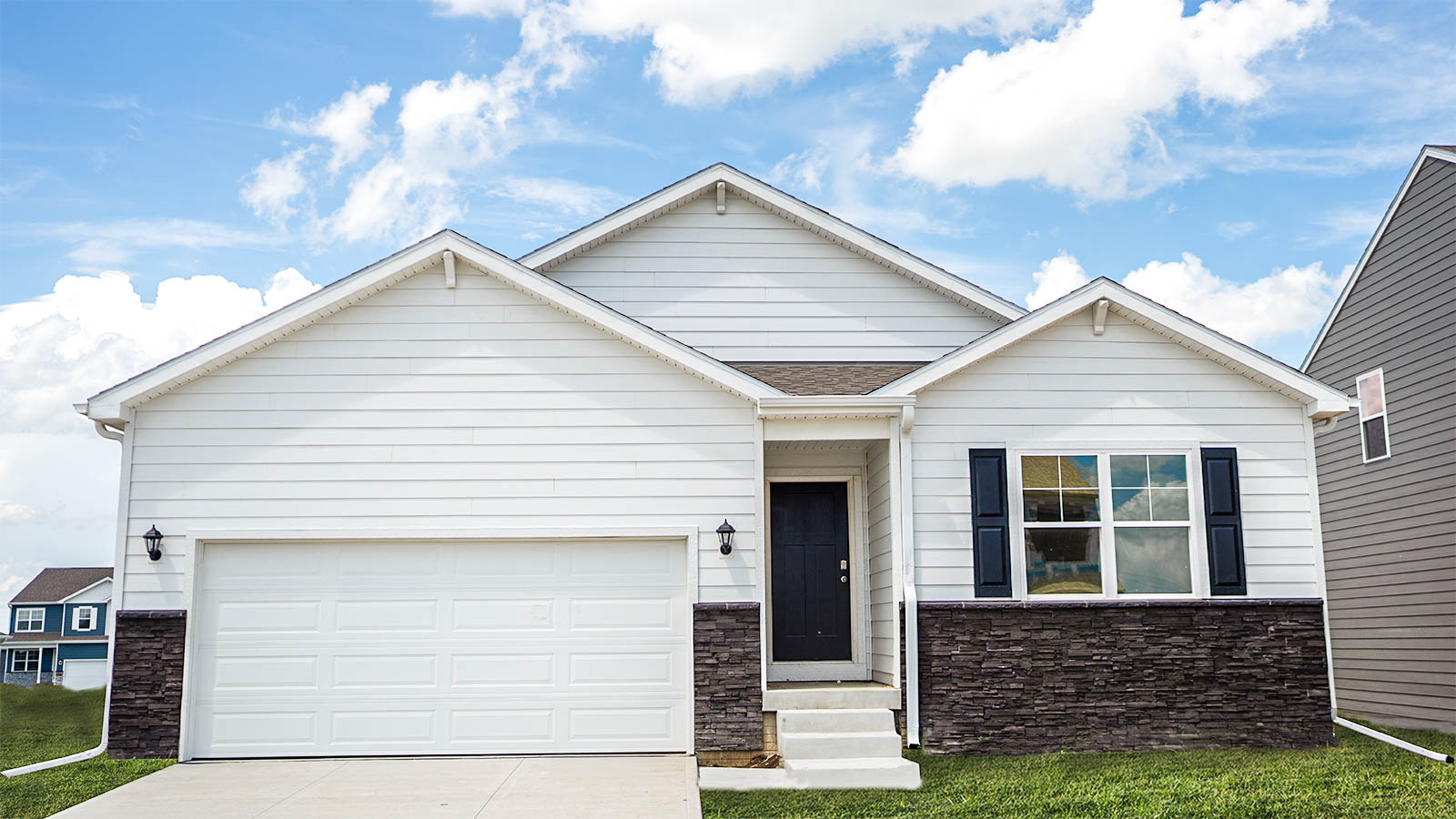 Exterior of Neuville, 2 car garage, ranch style home with white siding