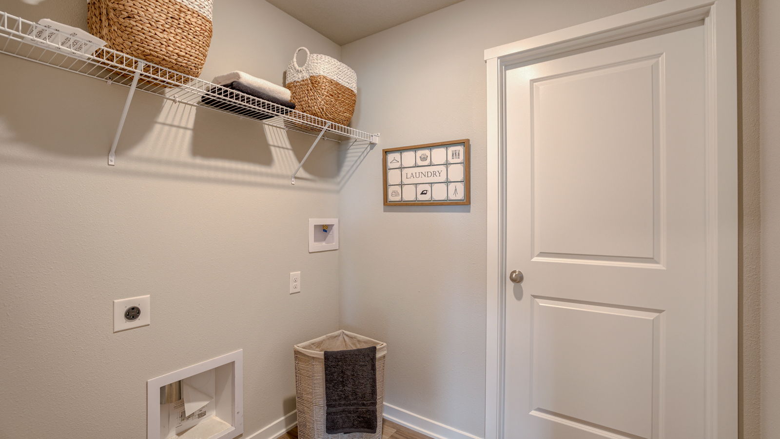 Utility laundry smartly designed with overhead storage, a drop zone, washer, dryer and hookups included