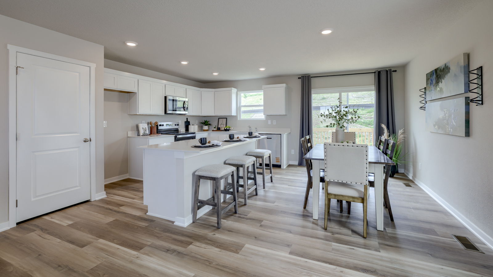 View from entry to kitchen with island, new appliance suite included, pantry and cabinet selections
