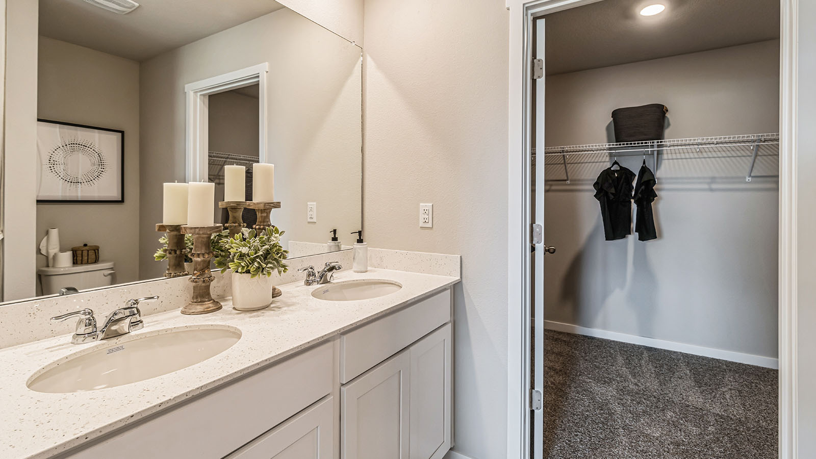 Primary bathroom with large mirror and walk-in closet